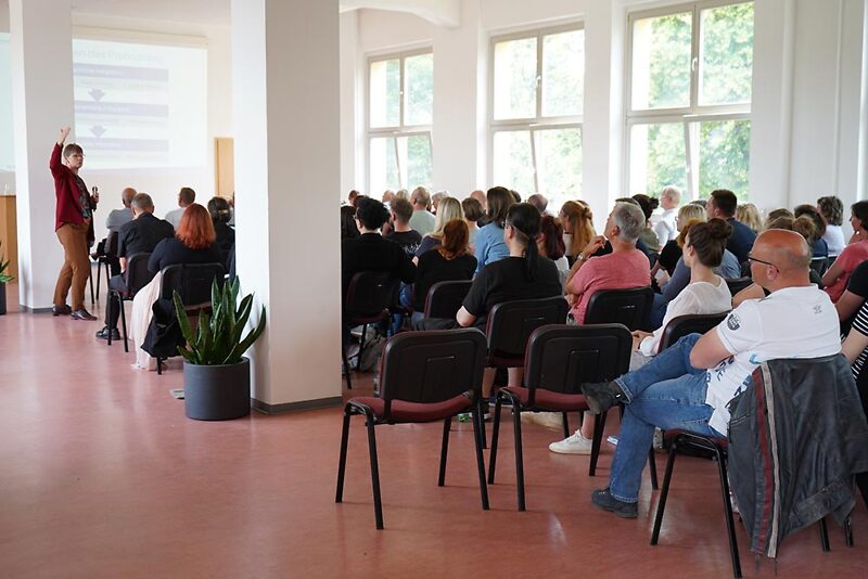 Mitarbeiterinnen und Mitarbeiter im Saal